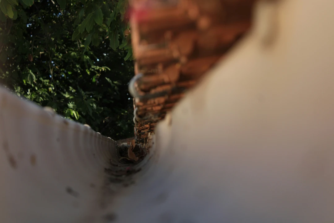 Split-screen showing clean functional gutter versus clogged overflowing gutter